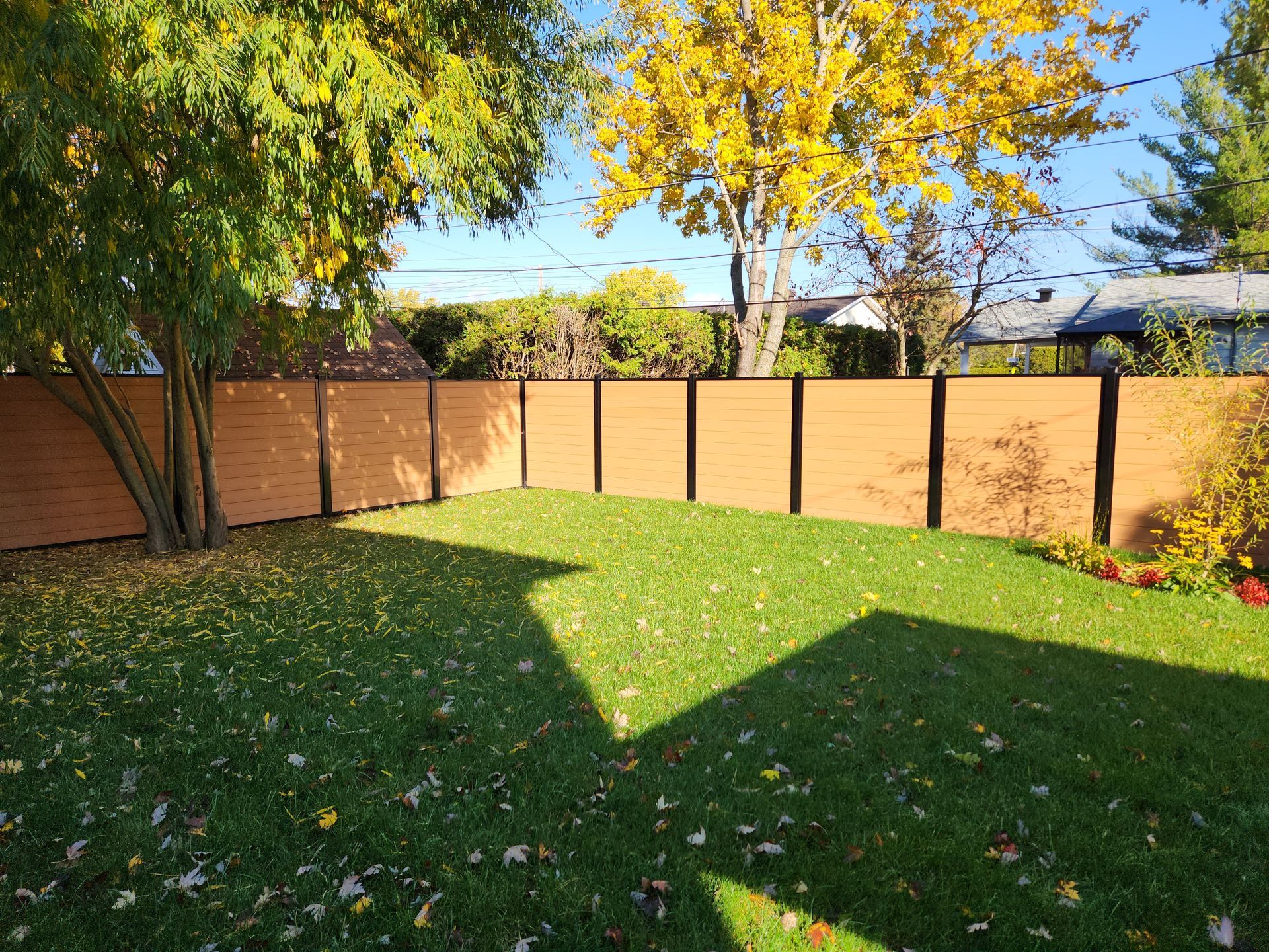 Une cour arriГЁre avec une clГґture en bois et des arbres en arriГЁre-plan.