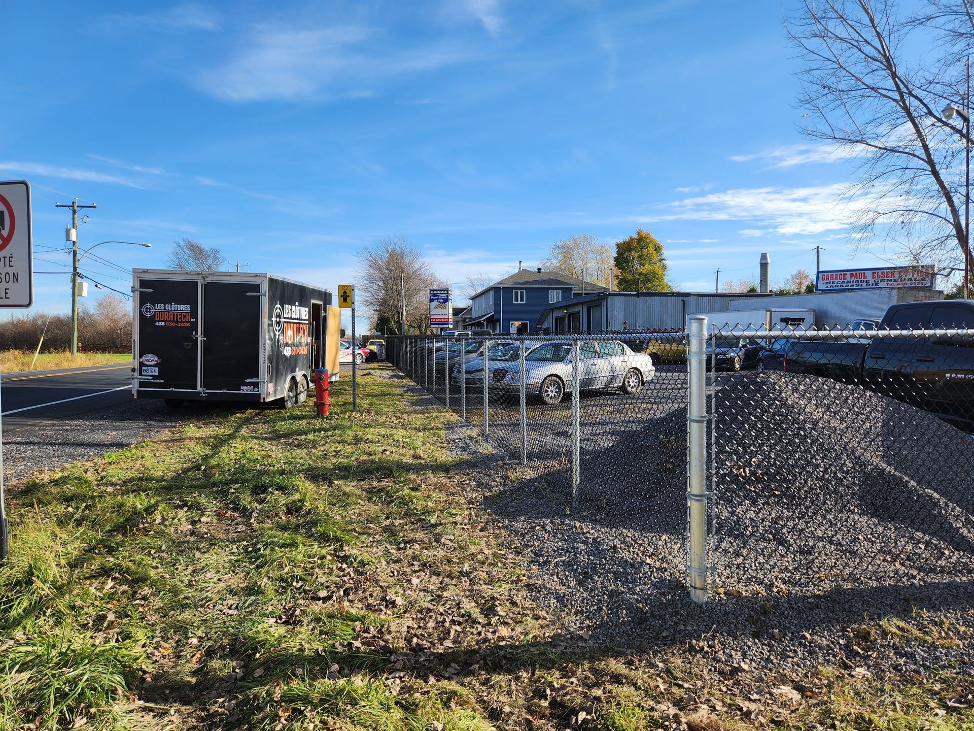 Un parking avec une clГґture et un panneau d'interdiction de stationnement.