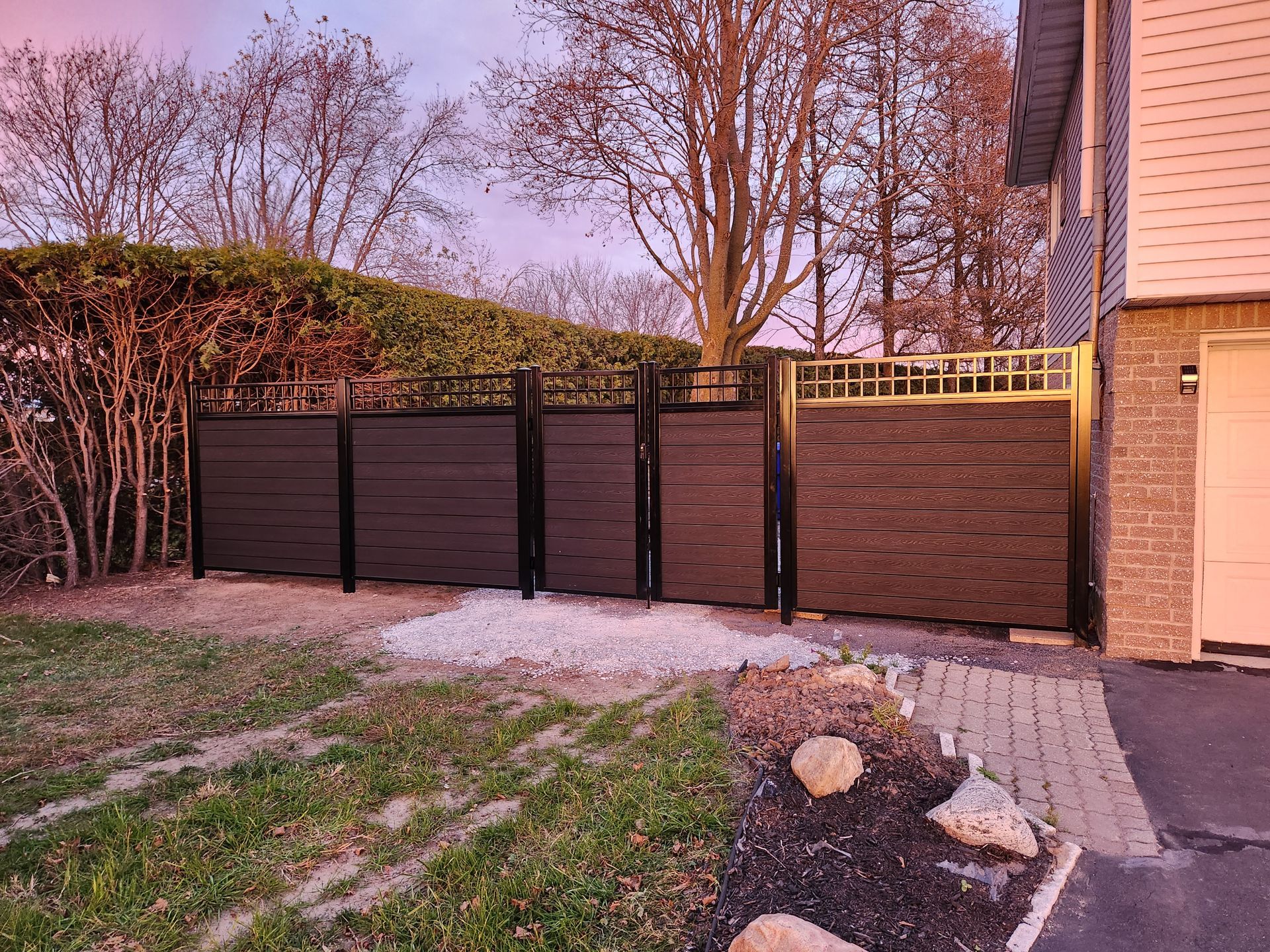 Une clГґture noire se trouve devant une maison.