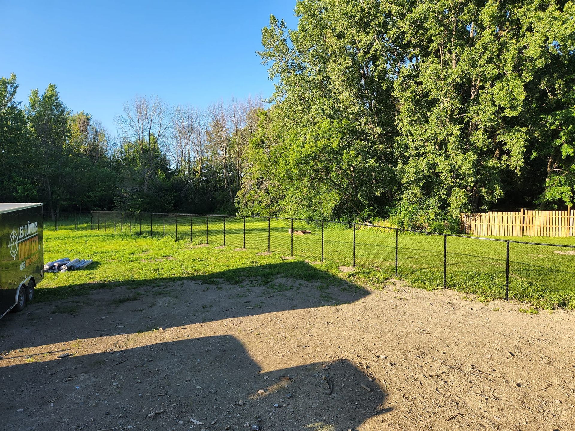 Une remorque est garГ©e au milieu d'un champ herbeux.