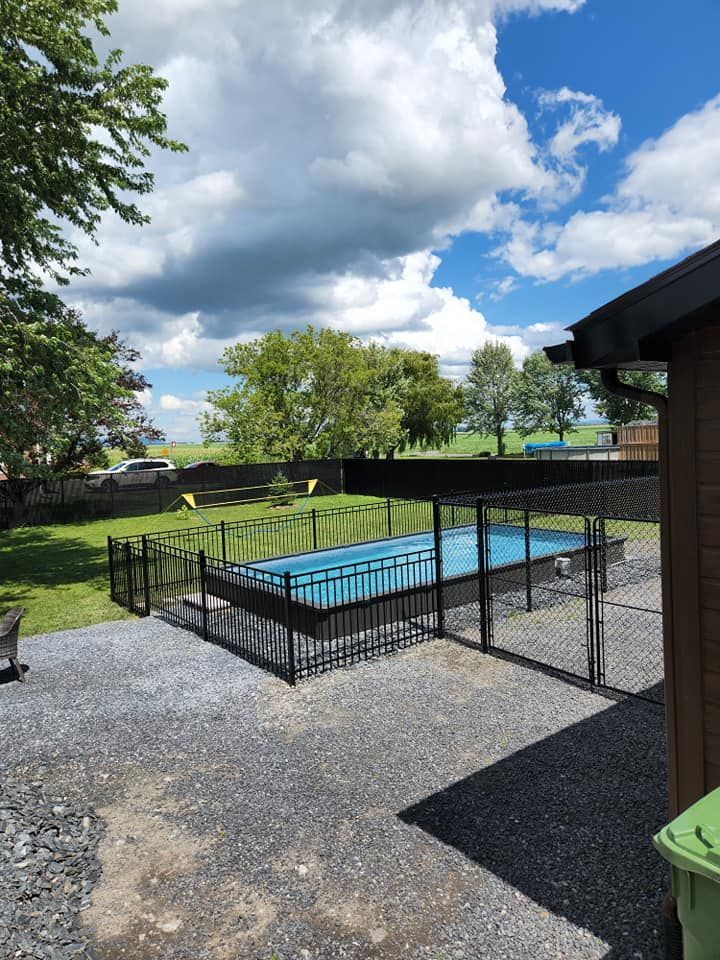 Une cour arriГЁre avec une clГґture et une piscine