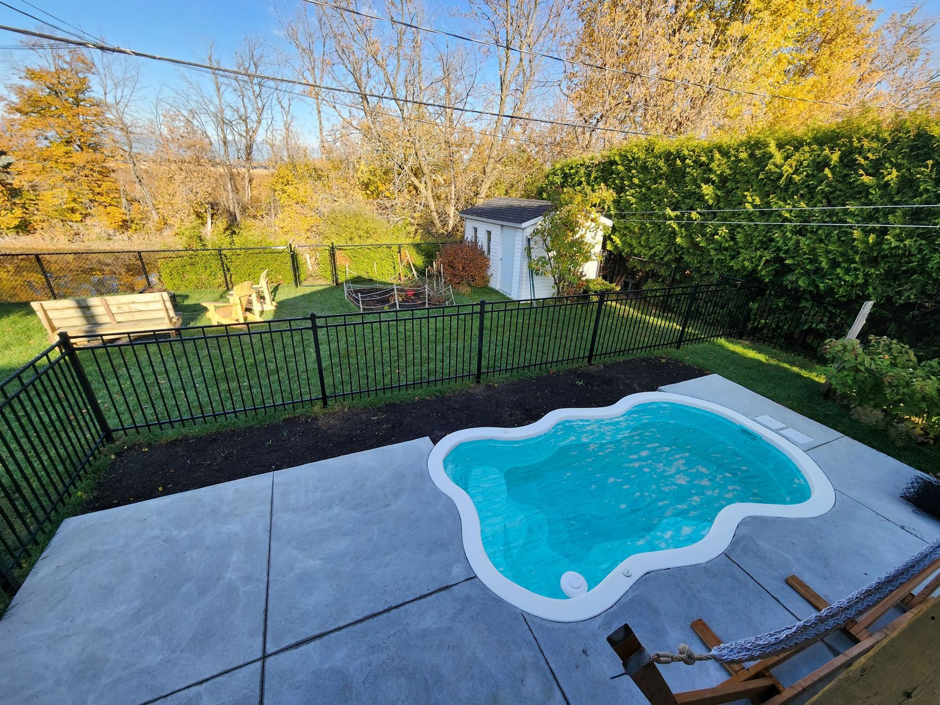 Une petite piscine se trouve dans l'arriГЁre-cour d'une maison.