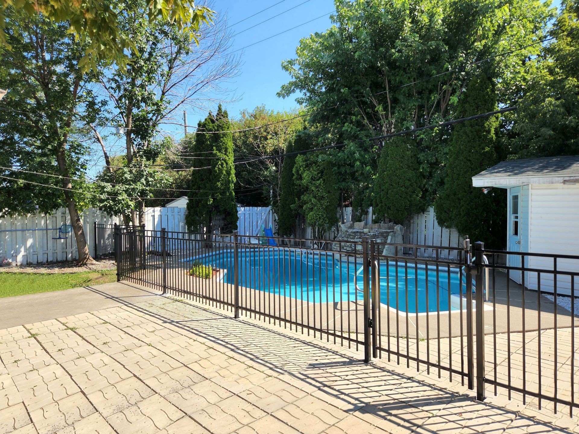 Une clГґture entoure une piscine dans une cour arriГЁre