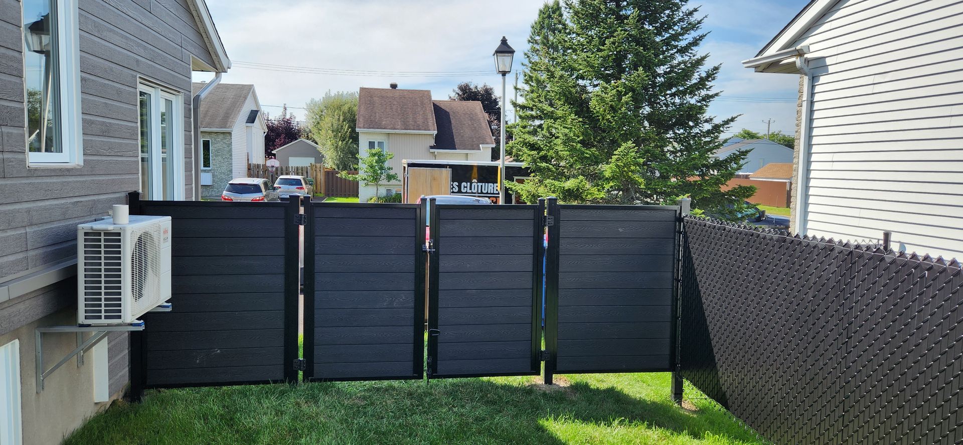 Une clГґture noire se trouve dans l'arriГЁre-cour d'une maison.