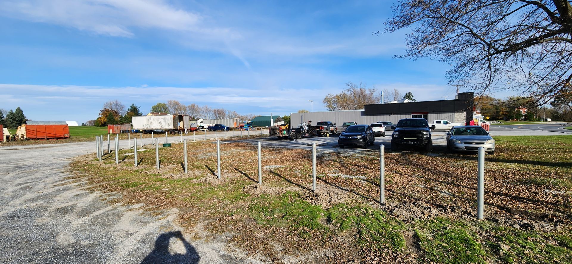 Beaucoup de voitures sont garГ©es sur un parking Г  cГґtГ© d'une clГґture.